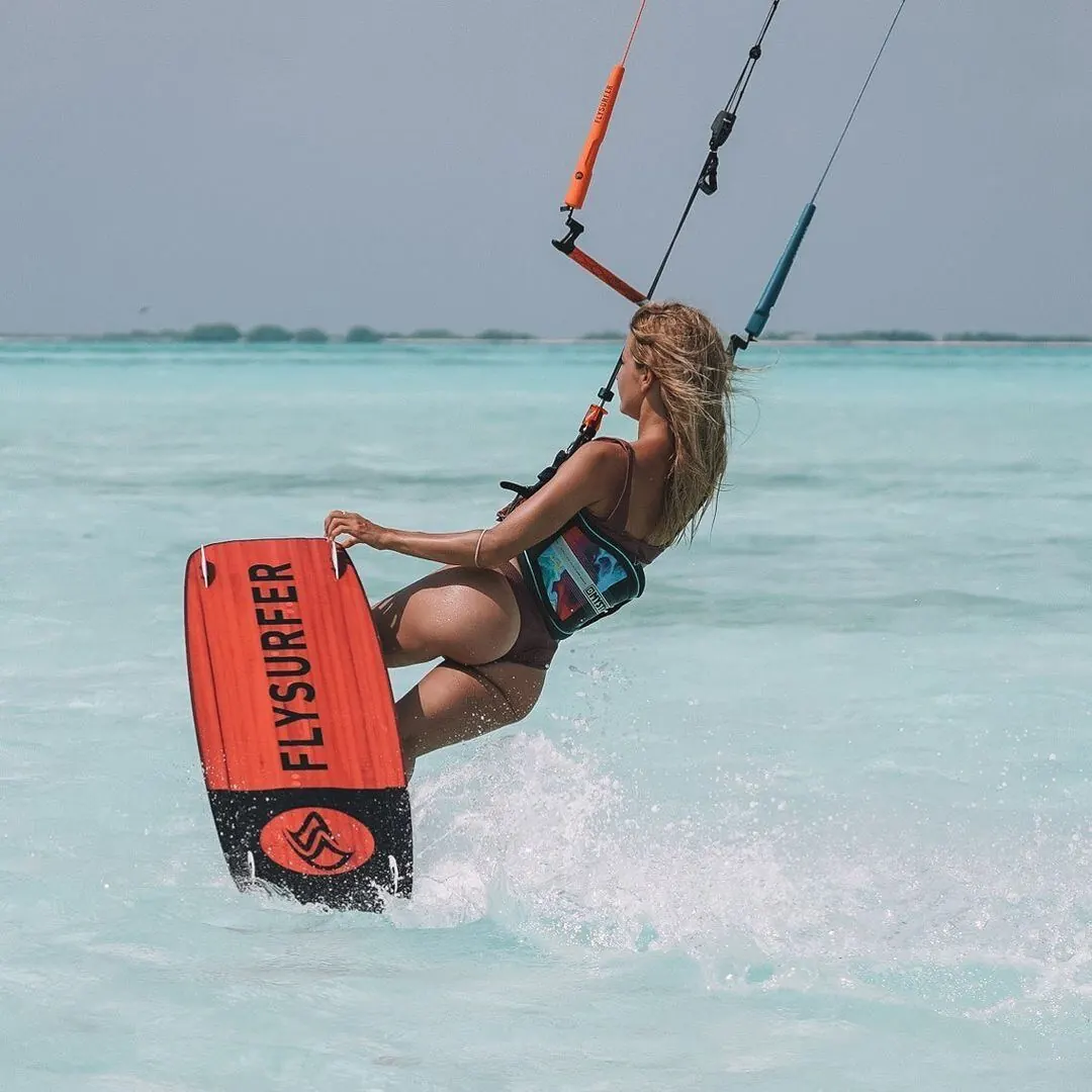 Close-up of a Flysurfer twintip carving through shallow Caribbean water