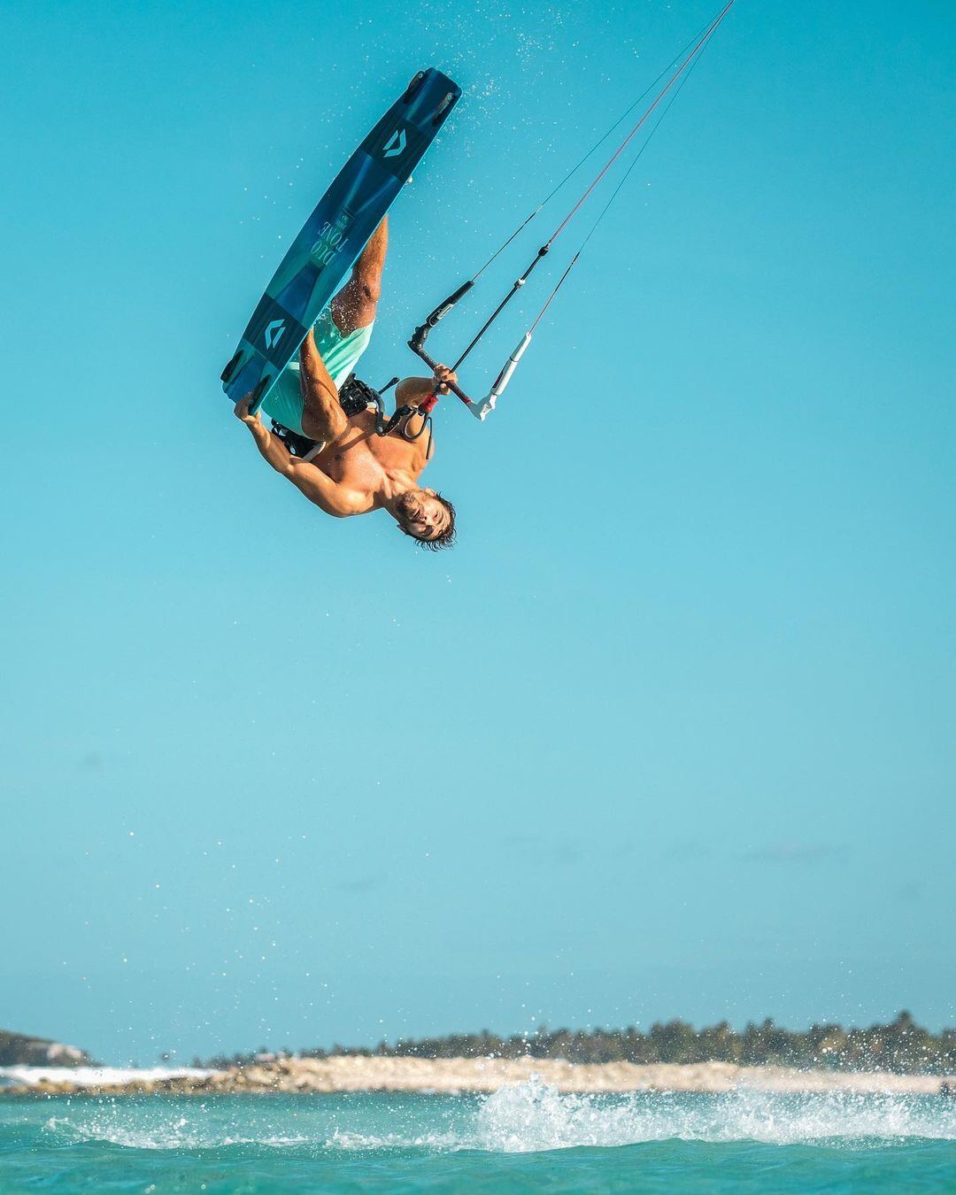 Kitesurfer mid-flip during a big air session